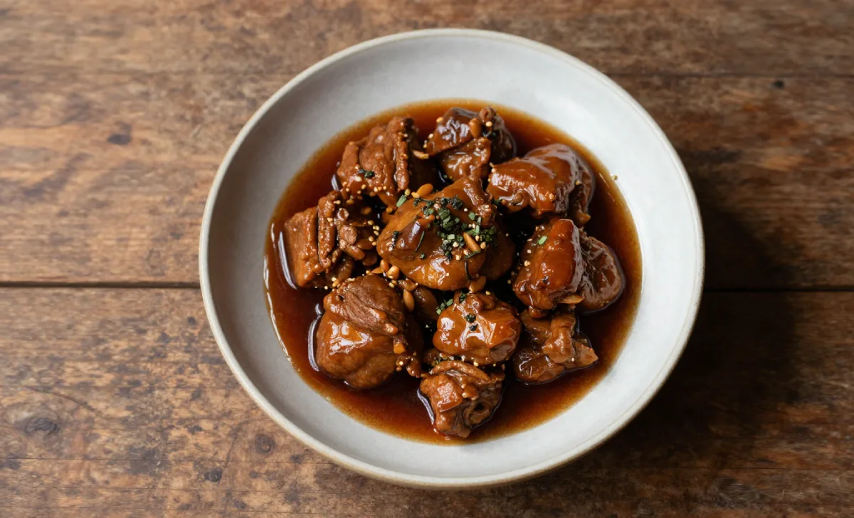A finished Fojatosgarto dish served in a shallow ceramic bowl with a glossy amber sauce and fresh herb garnish